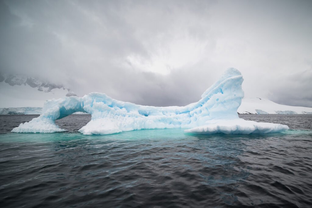 iceberg sea cloudy sky antarctica